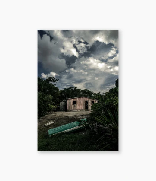 Barco verde e casa rosa na margem do rio sob nuvens, Amazônia – fotografia de André Nunez