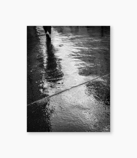 Figura refletida em rua molhada depois da chuva, Paris – fotografia de André Nunez