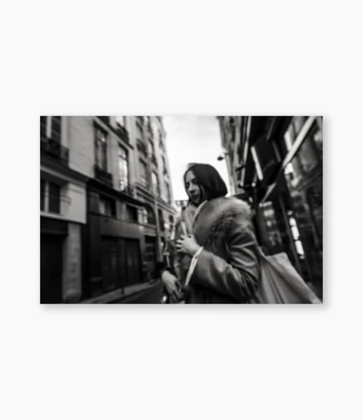 Mulher caminhando apressada em rua estreita de Paris, com movimento e desfoque – fotografia de André Nunez