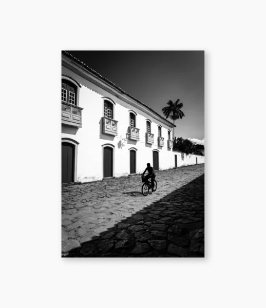 Homem atravessando rua entre luz forte e sombra – fotografia de André Nunez