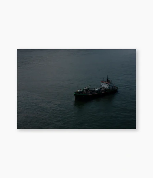 Navio na penumbra sobre água escura ao anoitecer – fotografia de André Nunez