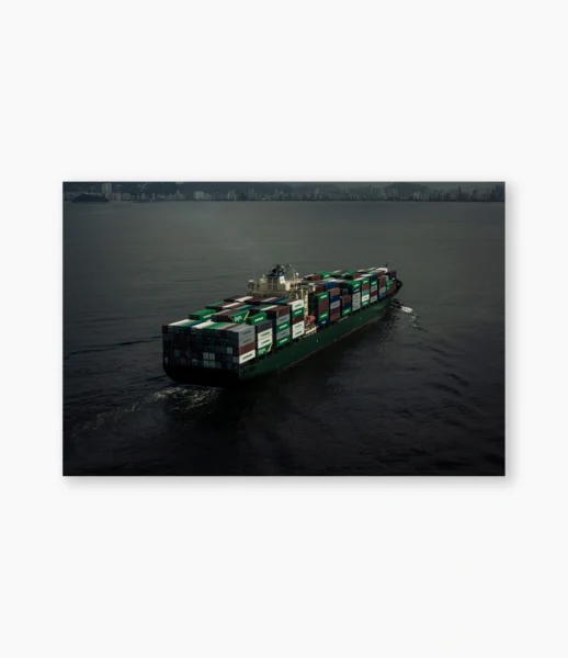 Navio com carga colorida visto do alto, seguindo junto à costa – fotografia de André Nunez