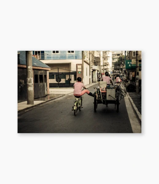 Mulher de bicicleta com criança numa rua de Shanghai pela manhã – fotografia de André Nunez